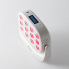 Trueons Quantum Mini angled view showing LED panel, blue LCD screen with session settings, and intensity controls
